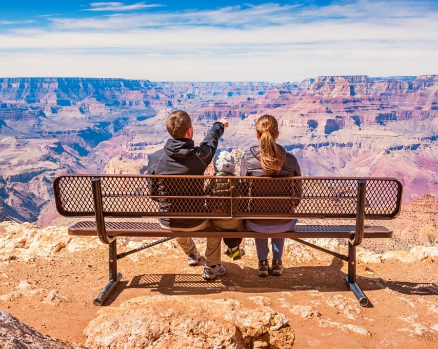 Stock photograph of a family with one child looking at view in Grand Canyon National Park, South Rim, USA on a sunny day.